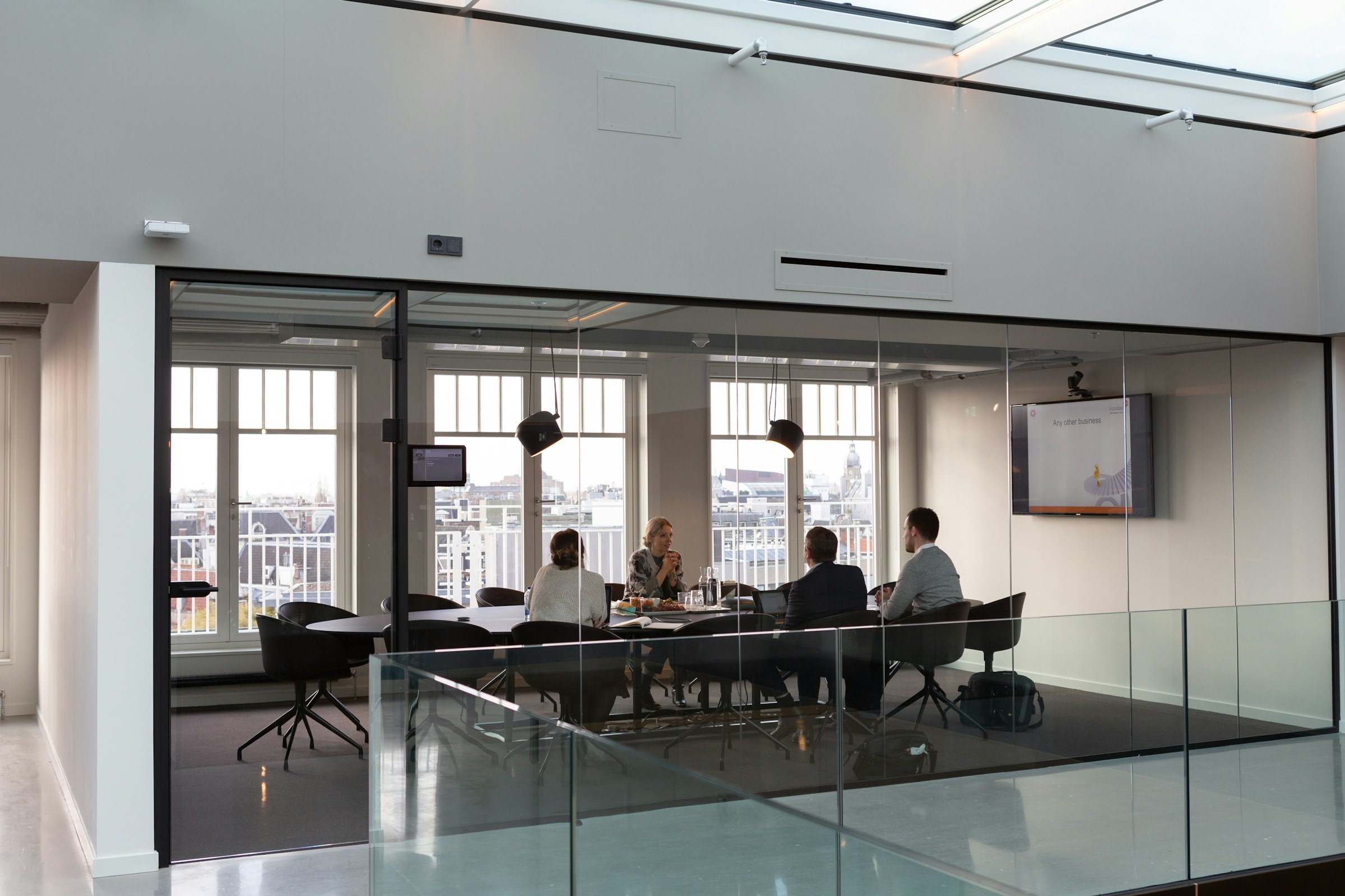 Glass-walled meeting room with a city skyline view