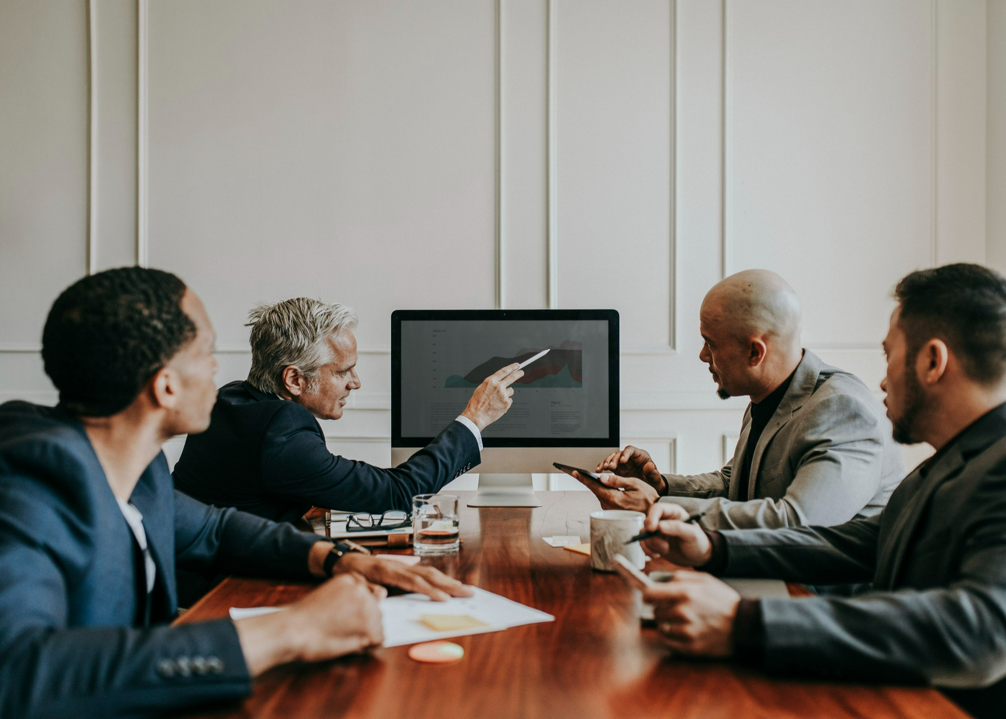Colleagues reviewing a chart on a screen in a boardroom